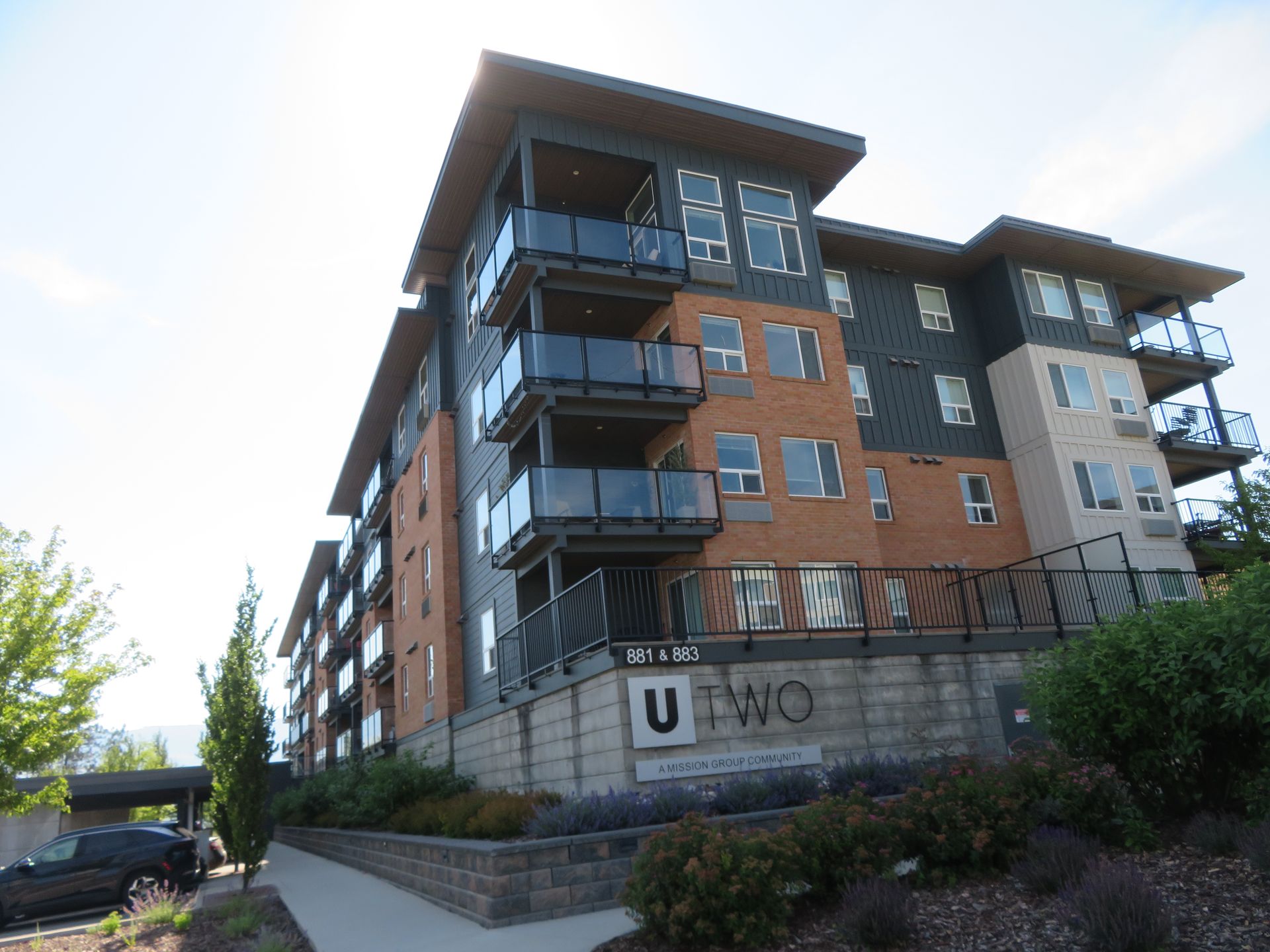 Five-storey residential building with glass balconies in Kelowna, photographed during a Strata Engineering site visit