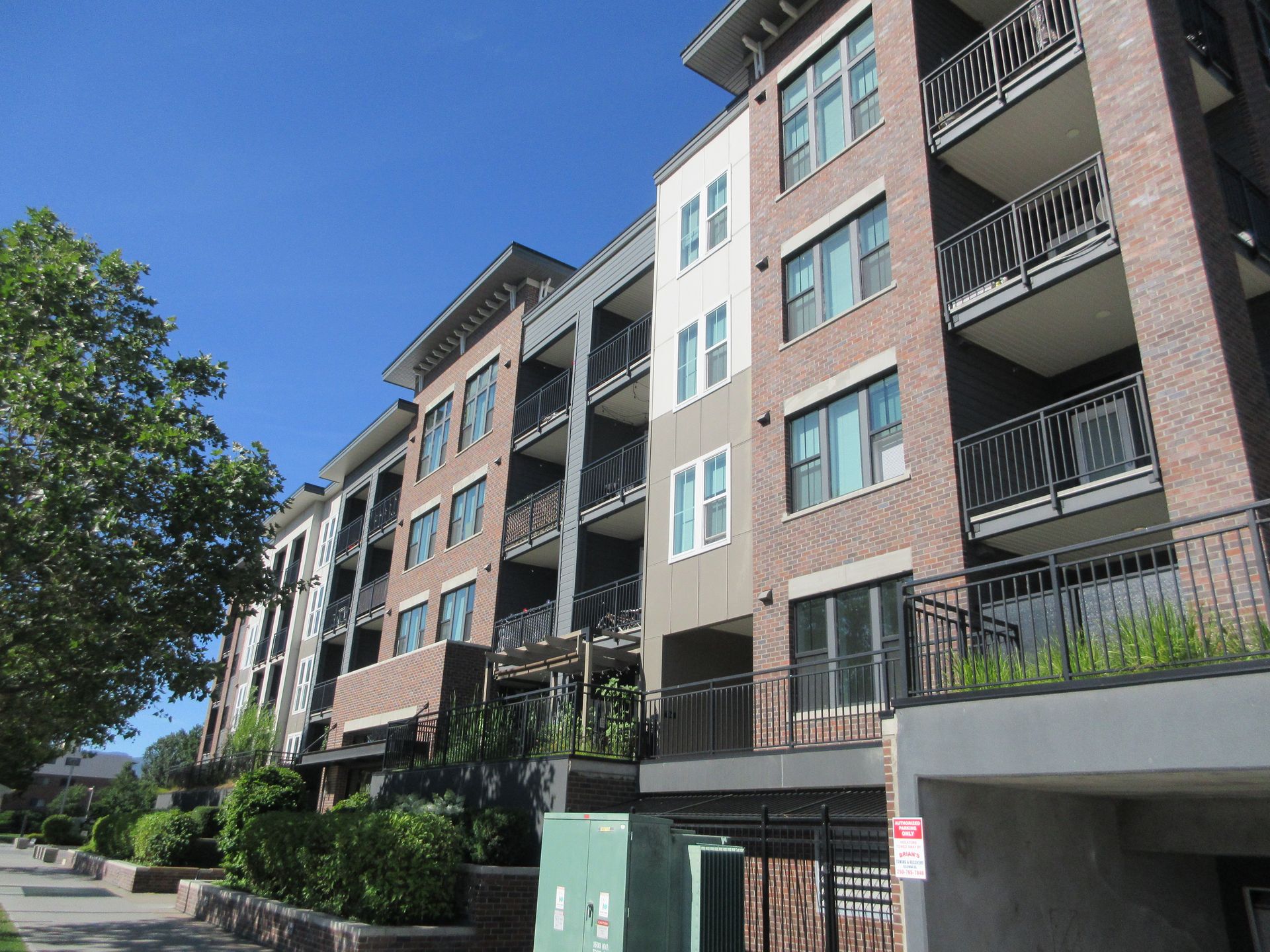 Multi-family residential building in Kelowna with brick facade and stacked balconies, photographed during a Strata Engineering site visit
